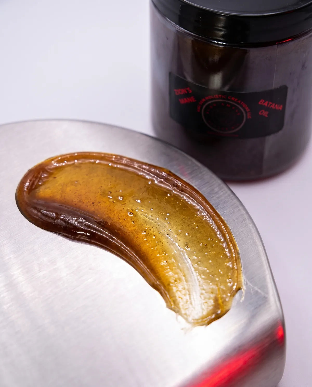 Softened batana, a few drops of black seed oil and dried sea moss side by side
